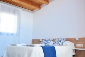 um quarto com 2 camas com almofadas brancas e azuis em Casa Rural Cal Saboner em Les Coves de Vinroma