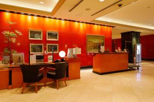 a lobby with red walls and a table and chairs at Hotel East 21 Tokyo in Tokyo
