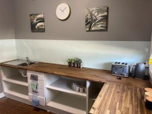 a kitchen counter with a sink and a clock on the wall at Colliery Inn Wallsend in Newcastle