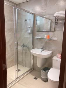 ein Bad mit einer Dusche, einem Waschbecken und einem WC in der Unterkunft Jin Zhan Hotel in Jincheng