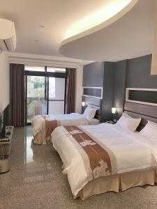 ein Hotelzimmer mit 2 Betten und einem TV in der Unterkunft Jin Zhan Hotel in Jincheng