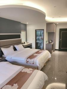 a hotel room with two beds and a bathroom at Jin Zhan Hotel in Jincheng