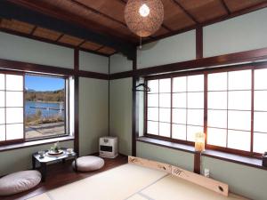 Habitación con 2 ventanas y mesa con TV. en Guest House Zen, en Yamanakako