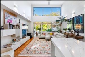 a living room with white furniture and a large window at Noosa Villas in Noosaville