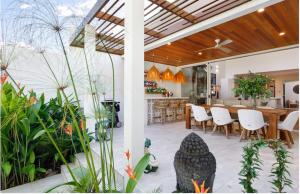 a kitchen and dining room with a table and some plants at Noosa Villas in Noosaville