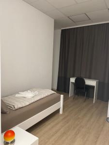 a bedroom with a bed and a desk and a chair at Recreo Pension Untereisesheim in Untereisesheim