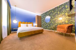 a hotel room with a bed and a chair at Designer Apartment in the City Center in Cluj-Napoca