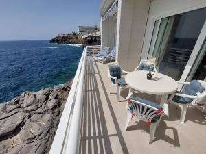 balkon ze stołem i krzesłami oraz oceanem w obiekcie Love boat deluxe experience w mieście Callao Salvaje