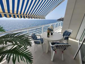 een balkon met een tafel en stoelen en de oceaan bij Love boat deluxe experience in Callao Salvaje