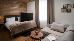 uma sala de estar com uma cama e um sofá em BODETALER BASECAMP LODGE - Bergsport- und Naturerlebnishotel em Rübeland