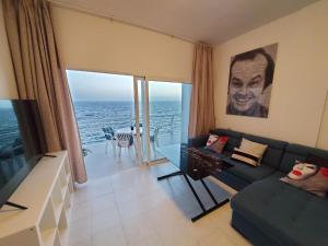 een woonkamer met een bank en uitzicht op de oceaan bij Love boat deluxe experience in Callao Salvaje