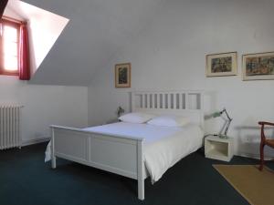 um quarto com uma cama branca e uma janela em Maison de Marie em Pont-Sainte-Maxence