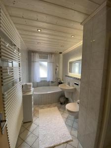 uma casa de banho com uma banheira, um WC e um lavatório. em Gästehaus Walter em Eisenberg