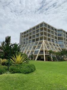 a large building with a green lawn in front of it at 9 Kyalanga Beach in Durban