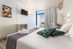 a hotel room with a large white bed with a window at Hippocampus Hotel in Naousa