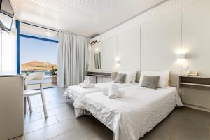 a bedroom with two beds and a large window at Hippocampus Hotel in Naousa