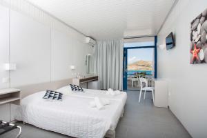a bedroom with two beds and a view of the ocean at Hippocampus Hotel in Naousa