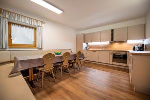 - une cuisine et une salle à manger avec une table et des chaises dans l'établissement Apartments La Rives, à Santa Cristina Valgardena