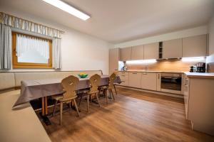 a kitchen and dining room with a table and chairs at Apartments La Rives in Santa Cristina Gherdëina