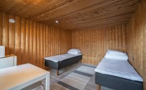 a room with two beds in a wooden room at Ivalo River Camping in Ivalo