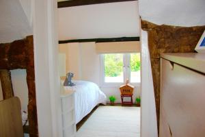 a bedroom with a bed and a window at Romantic* Castle on the Hill Cottage *Framlingham in Framlingham