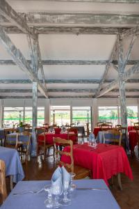 a dining room with tables and chairs with red tablecloths at Hotel Arcu Di Sole in Propriano