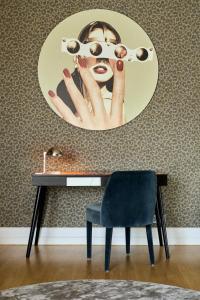 a painting of a woman sitting on a chair next to a lamp at H15 Boutique Hotel in Warsaw