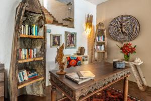 a room with a wooden table and bookshelves at Uzuri Boutique Hotel in Jambiani