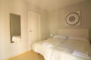 1 dormitorio con cama blanca y espejo en Apartamento Jerez, en Jerez de la Frontera