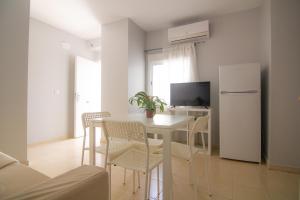 a kitchen with a white table and chairs and a refrigerator at Apartamento Jerez in Jerez de la Frontera