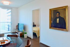 a living room with a painting of a man at Brand-New, Close to Centre, Rooftop-Summer-Pool in Vienna