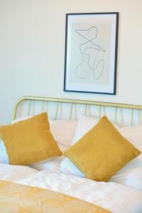 a bed with two pillows and a picture on the wall at Brand-New, Close to Centre, Rooftop-Summer-Pool in Vienna +20 photos