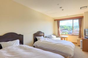 Habitación de hotel con 2 camas y ventana en Fuji Matsuzono Hotel, en Yamanakako