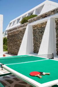 a ping pong table with two bats and a ping pong ball at Hippocampus Hotel in Naousa