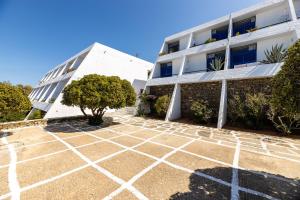 a white building with a tree in front of it at Hippocampus Hotel in Naousa