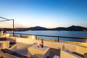 a balcony with a table with a bottle of wine at Hippocampus Hotel in Naousa
