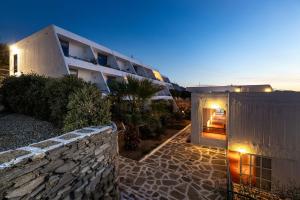 a building with a stone wall next to a building at Hippocampus Hotel in Naousa