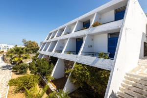 an apartment building with white balconies and plants at Hippocampus Hotel in Naousa