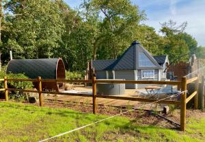 a small house with a fence in front of it at Luxe Finse Kota met Jacuzzi en SaunaBarrel de Zandhoef in Eersel