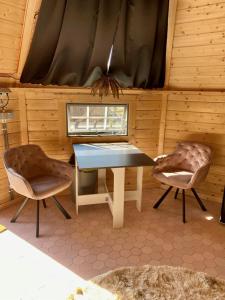 een eetkamer met een tafel en 2 stoelen bij Luxe Finse Kota met Jacuzzi en SaunaBarrel de Zandhoef in Eersel