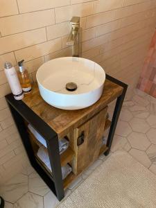 y baño con lavabo blanco sobre una mesa de madera. en Luxe Finse Kota met Jacuzzi en SaunaBarrel de Zandhoef, en Eersel