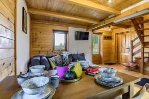 a wooden cabin with a table with dishes on it at Oaza Mazurska - Domek z kominkiem in Piecki