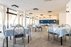a dining room with white tables and chairs at Hippocampus Hotel in Naousa