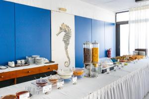 a long table with food on it with a seahorse on the wall at Hippocampus Hotel in Naousa