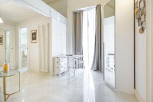Una sala de estar blanca con una mesa y sillas. en Home dentro il teatro, en Catania 186 fotos más