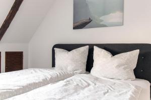 a bedroom with a bed with white sheets and pillows at Ferienwohnungen im Weingarten Quedlinburg in Quedlinburg