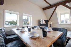 a dining room with a wooden table and chairs at Ferienwohnungen im Weingarten Quedlinburg in Quedlinburg