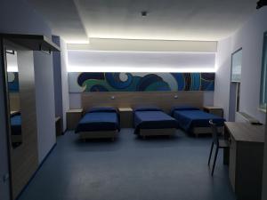 een kamer met drie bedden en een schilderij aan de muur bij Hotel Clodi in Ascoli Piceno