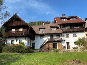 a large white house with a brown roof at Gailtal Appartements Nähe Skigebiet in Wertschach