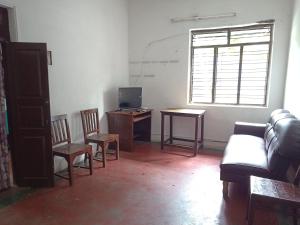 a living room with a couch and chairs and a desk at vacation Home Stay in Pondicherry